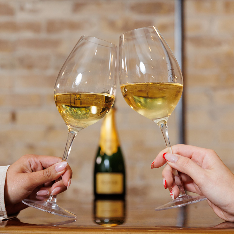 Two wine glasses toasting